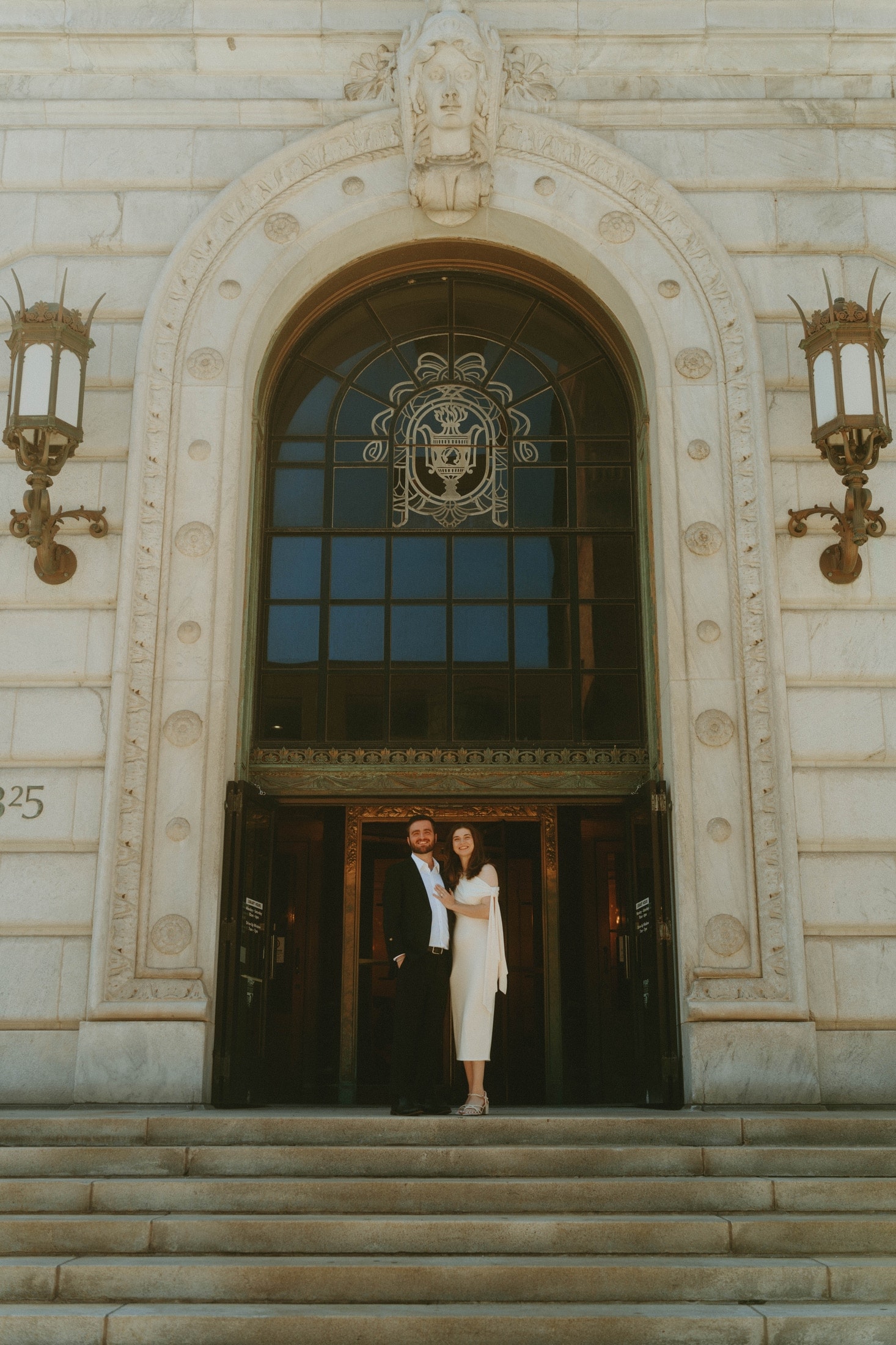 Tylar and Carly standing before grand ornate entrance doors