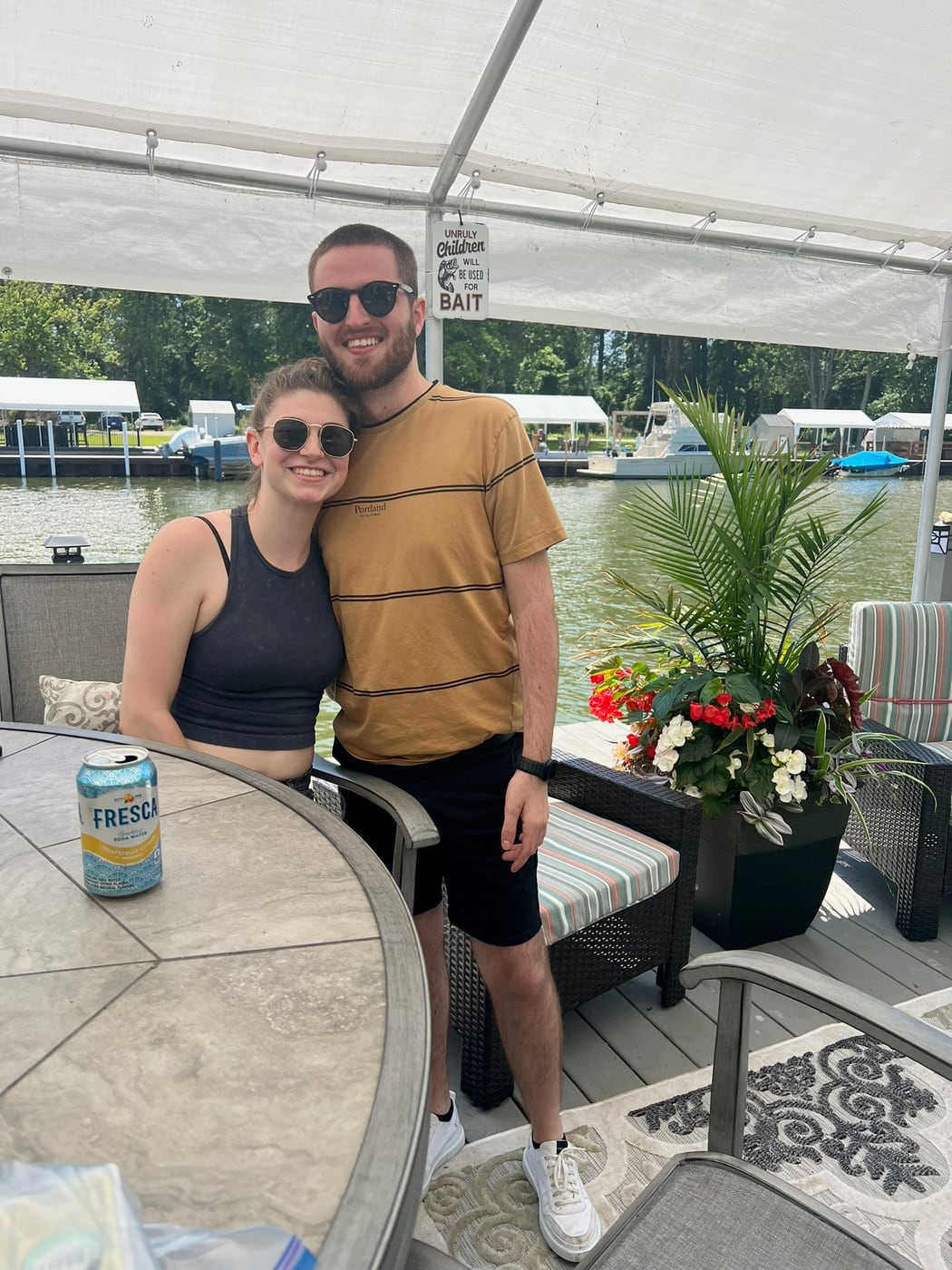 Tylar and Carly under a canopy at the lake in summer