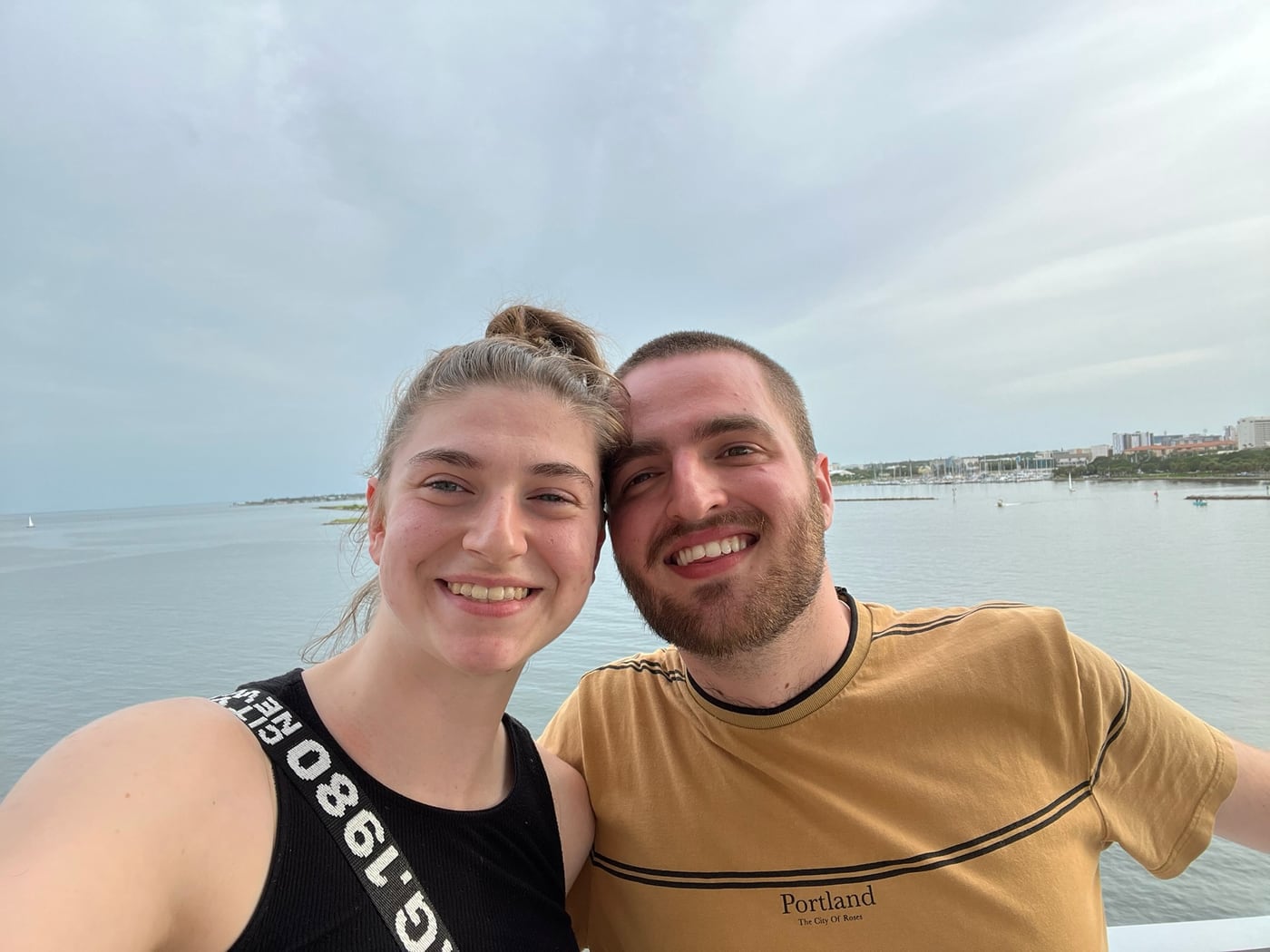 Tylar and Carly on a waterfront boardwalk under an overcast sky
