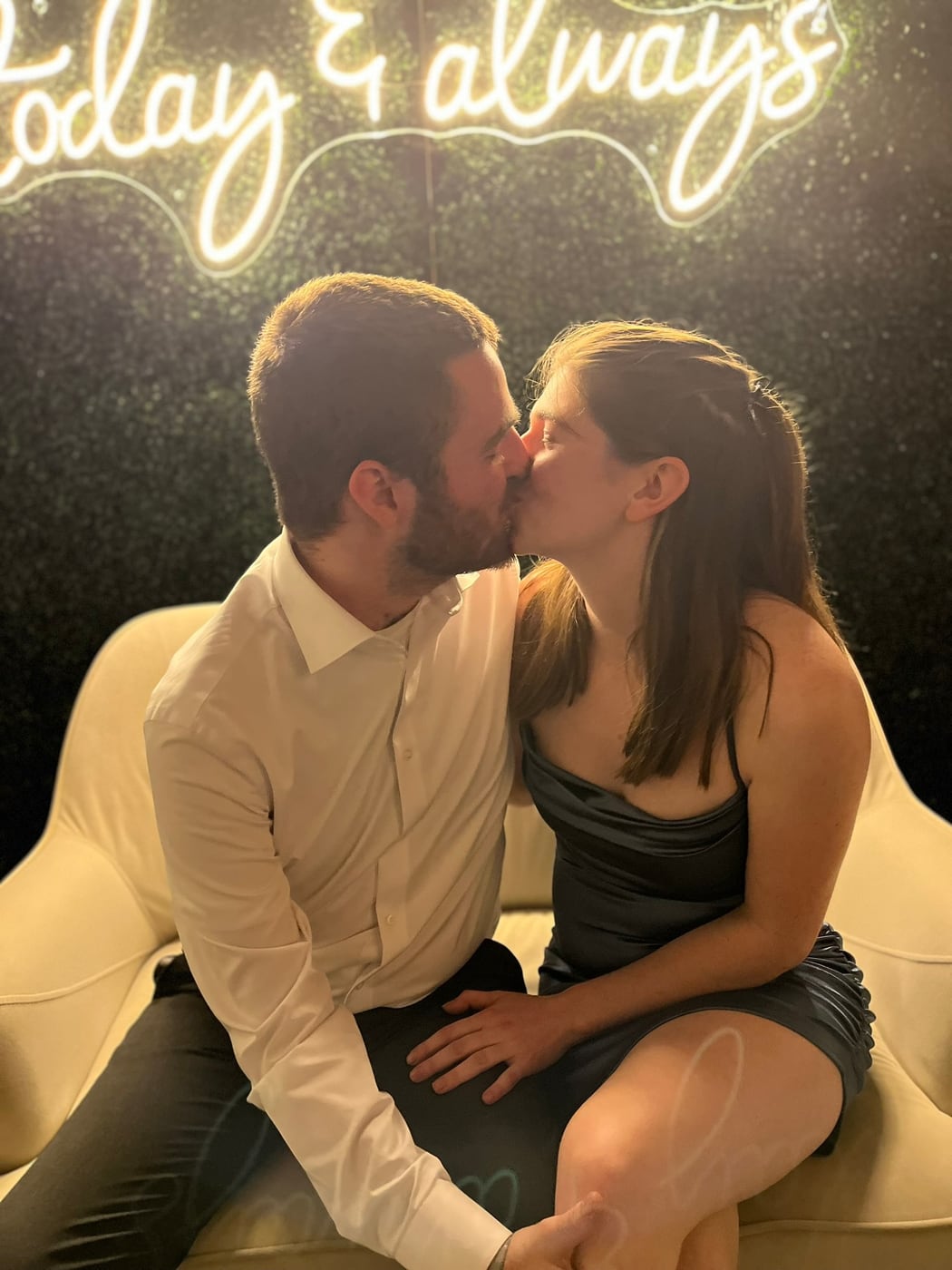 Tylar and Carly kissing beneath a neon sign reading today and always