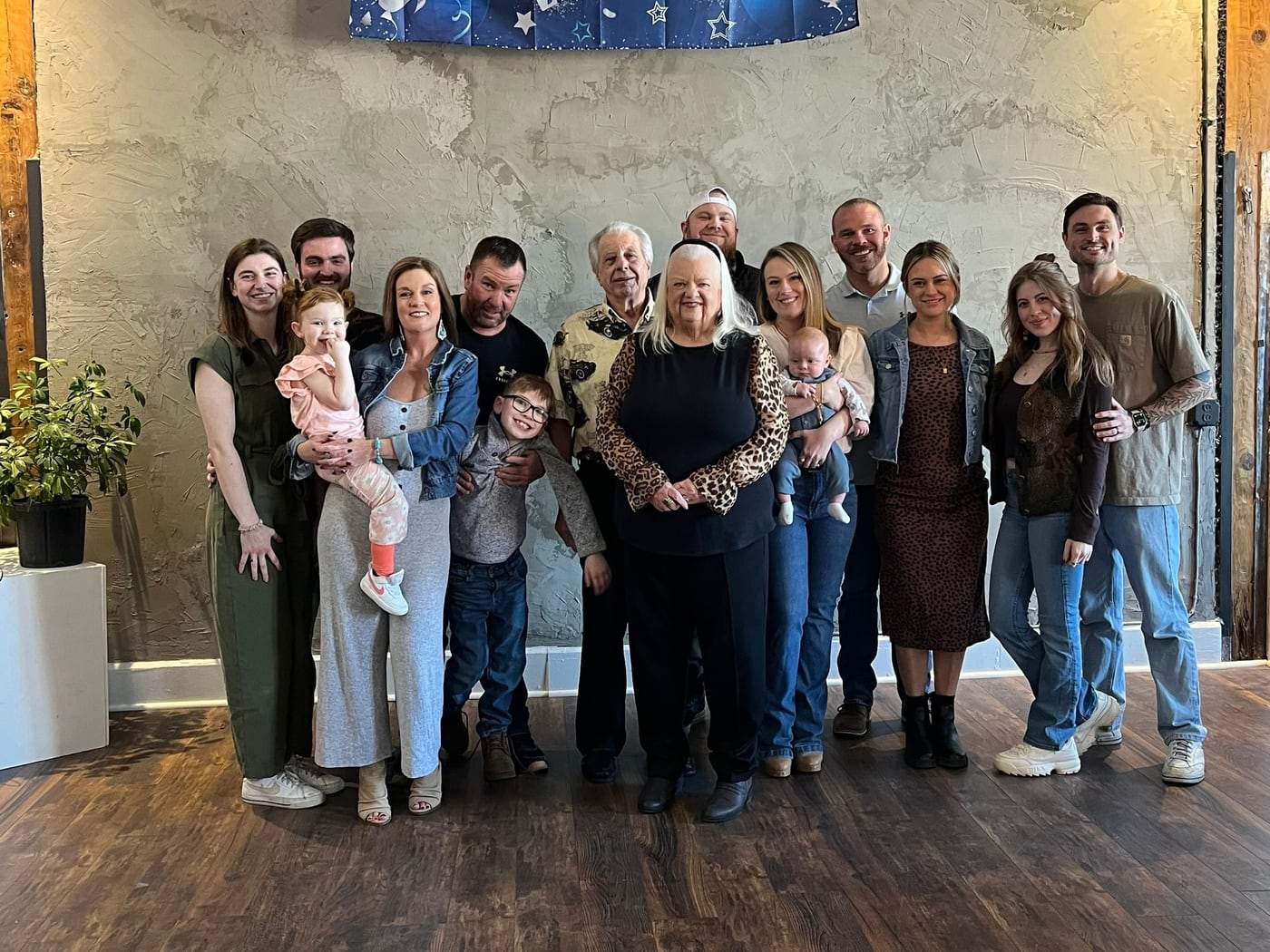 Tylar and Carly with the extended family, posed against a pale wall