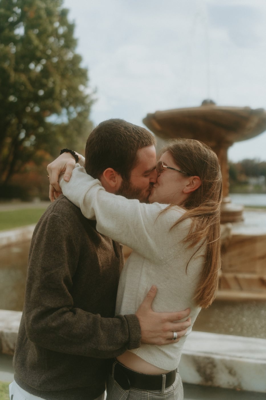 Tylar and Carly embracing in front of a stone fountain
