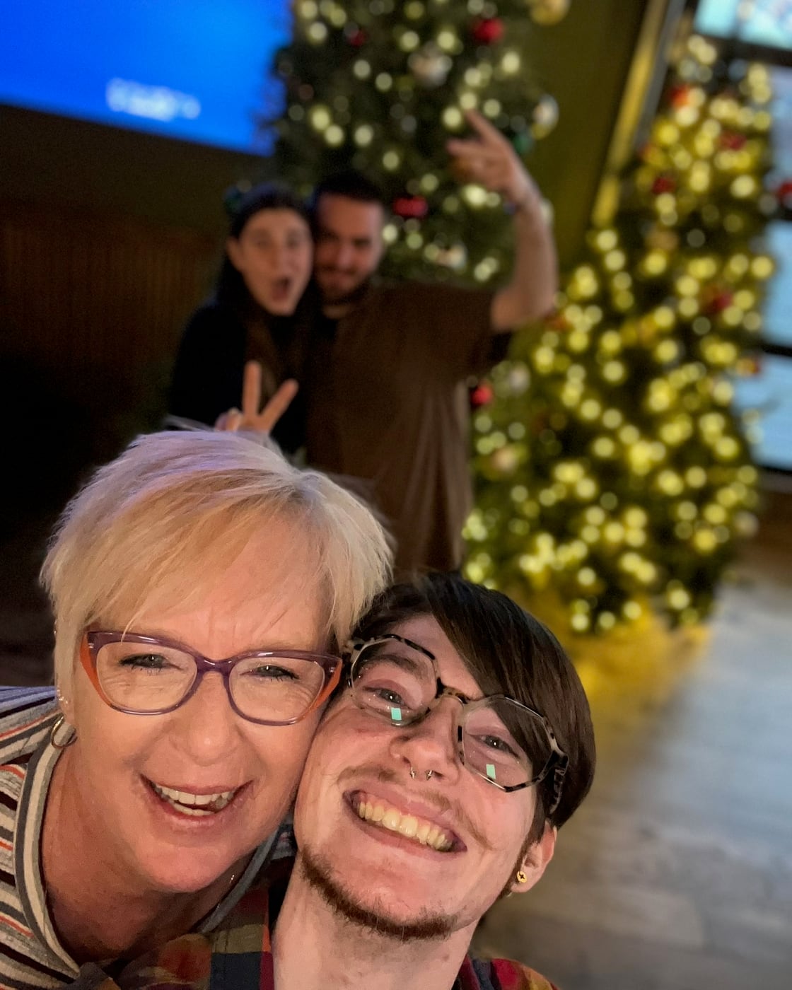 Family gathered beside a Christmas tree