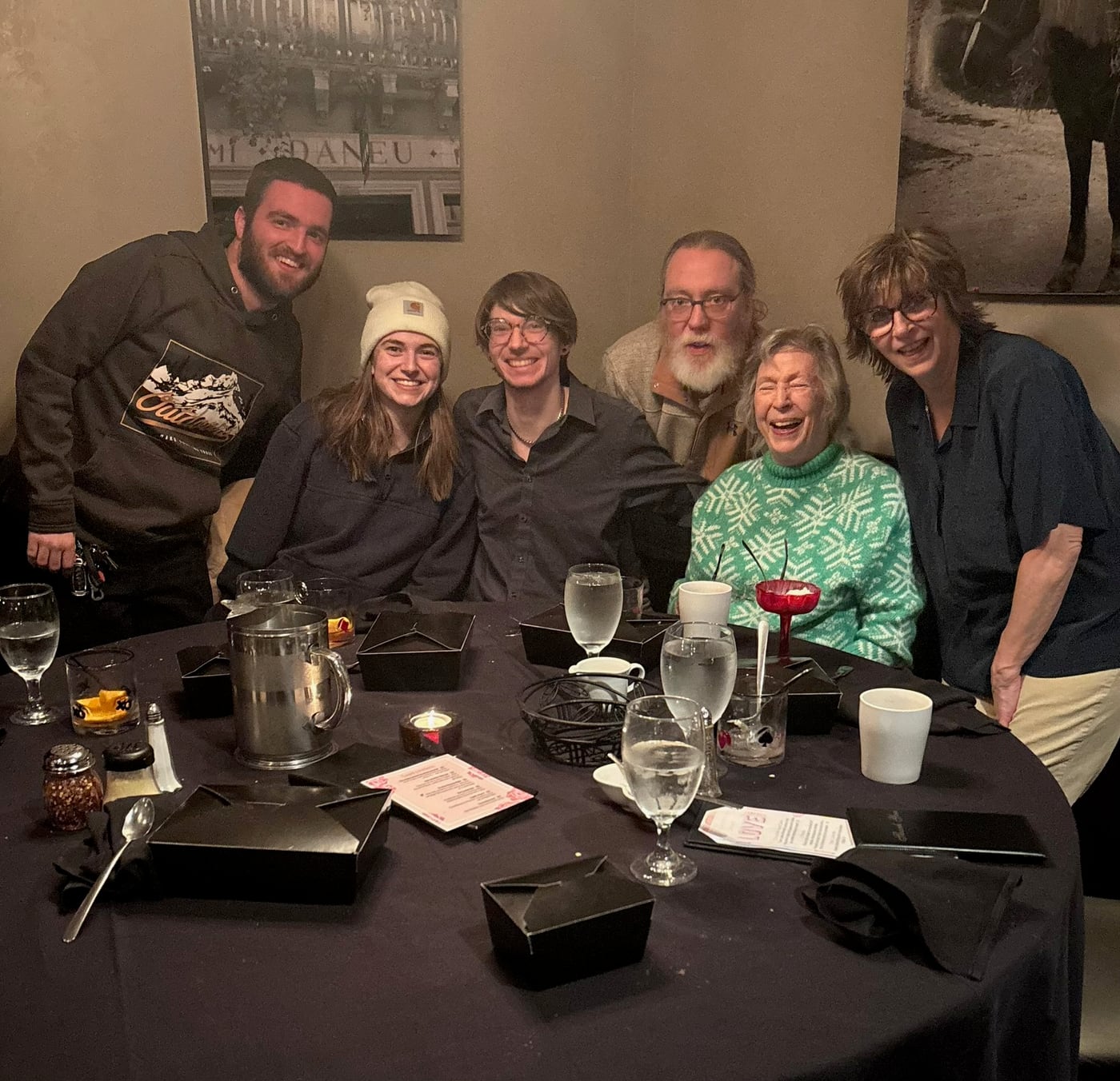 Tylar and Carly at a long restaurant table with family