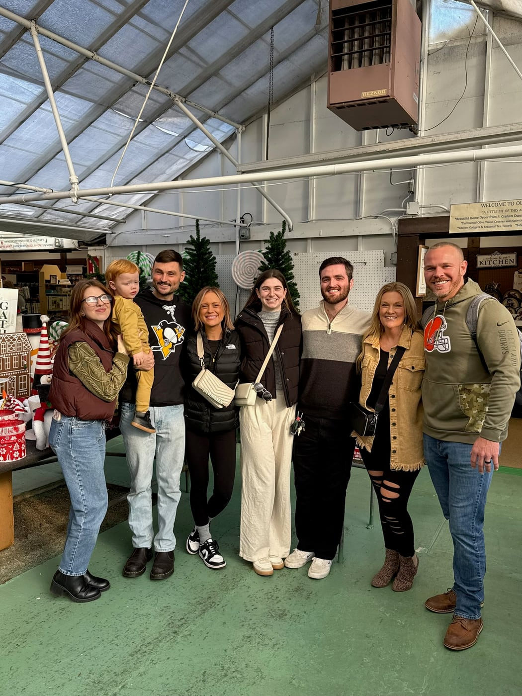 Tylar and Carly with family among Christmas trees at an indoor market