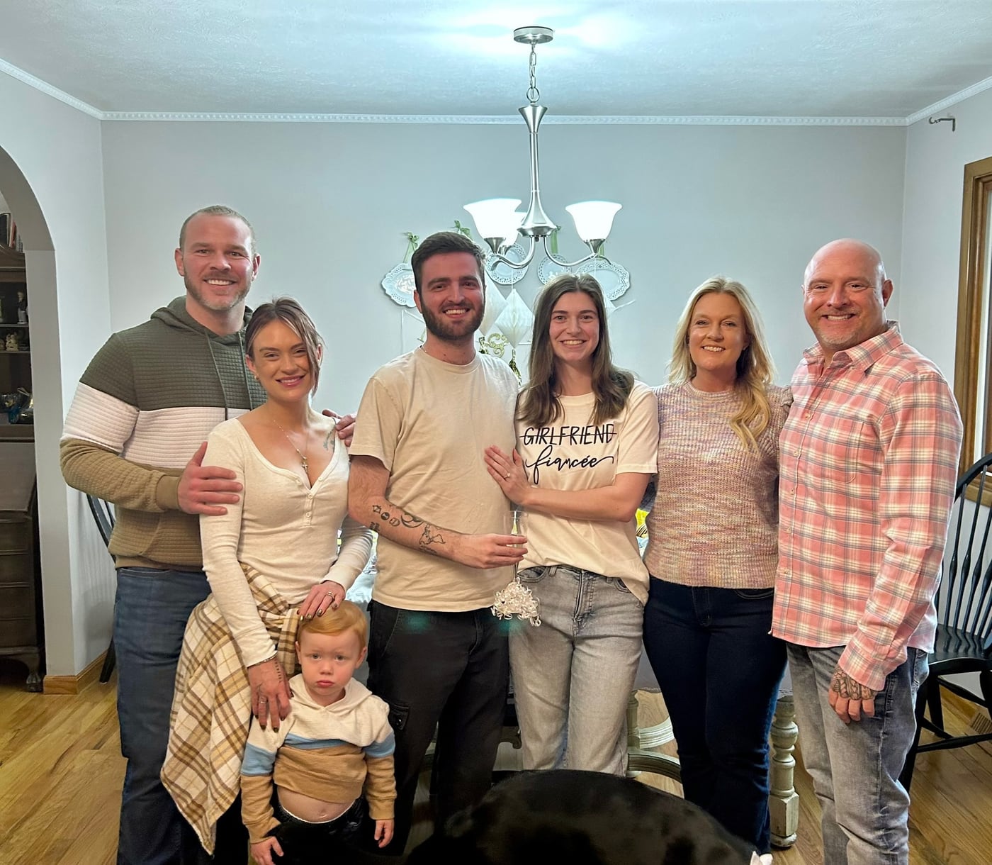 Tylar and Carly with family and a toddler in a living room