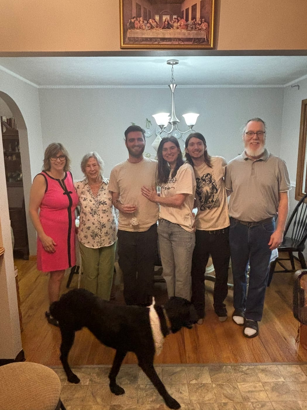 Tylar and Carly with family and their dog in a living room