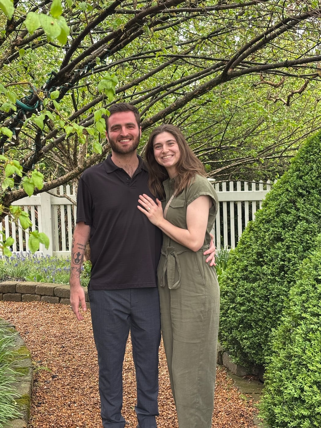 Tylar and Carly under blossoming trees, her hand on his chest