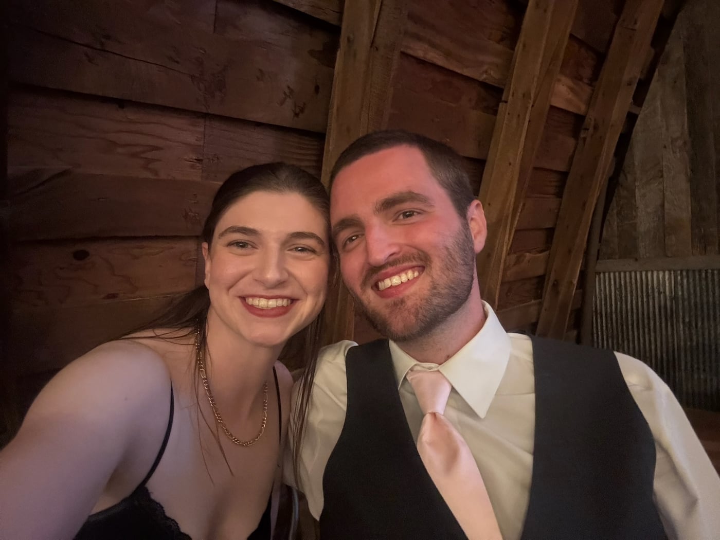 Tylar and Carly dressed up inside a barn, cheek to cheek