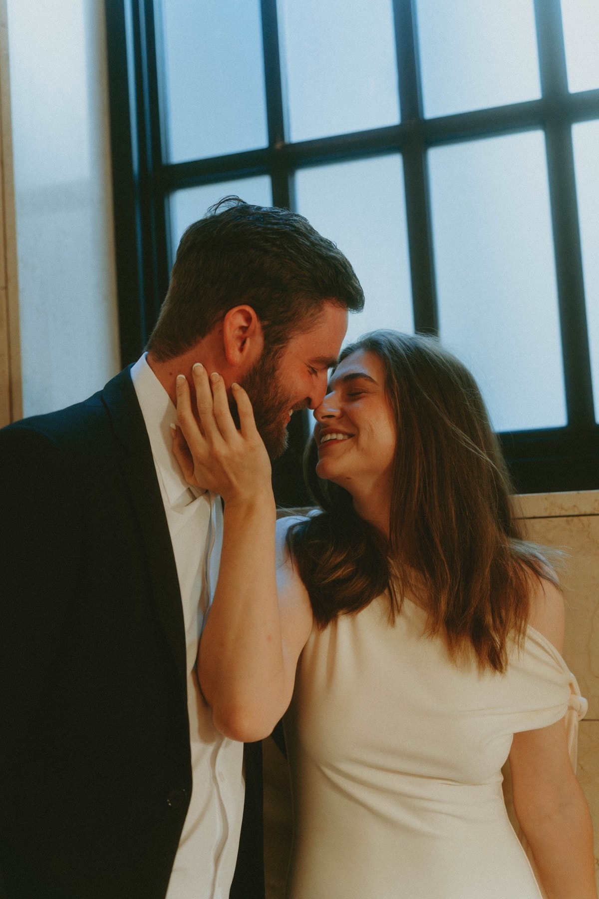 Tylar and Carly sharing a near-kiss by a tall window