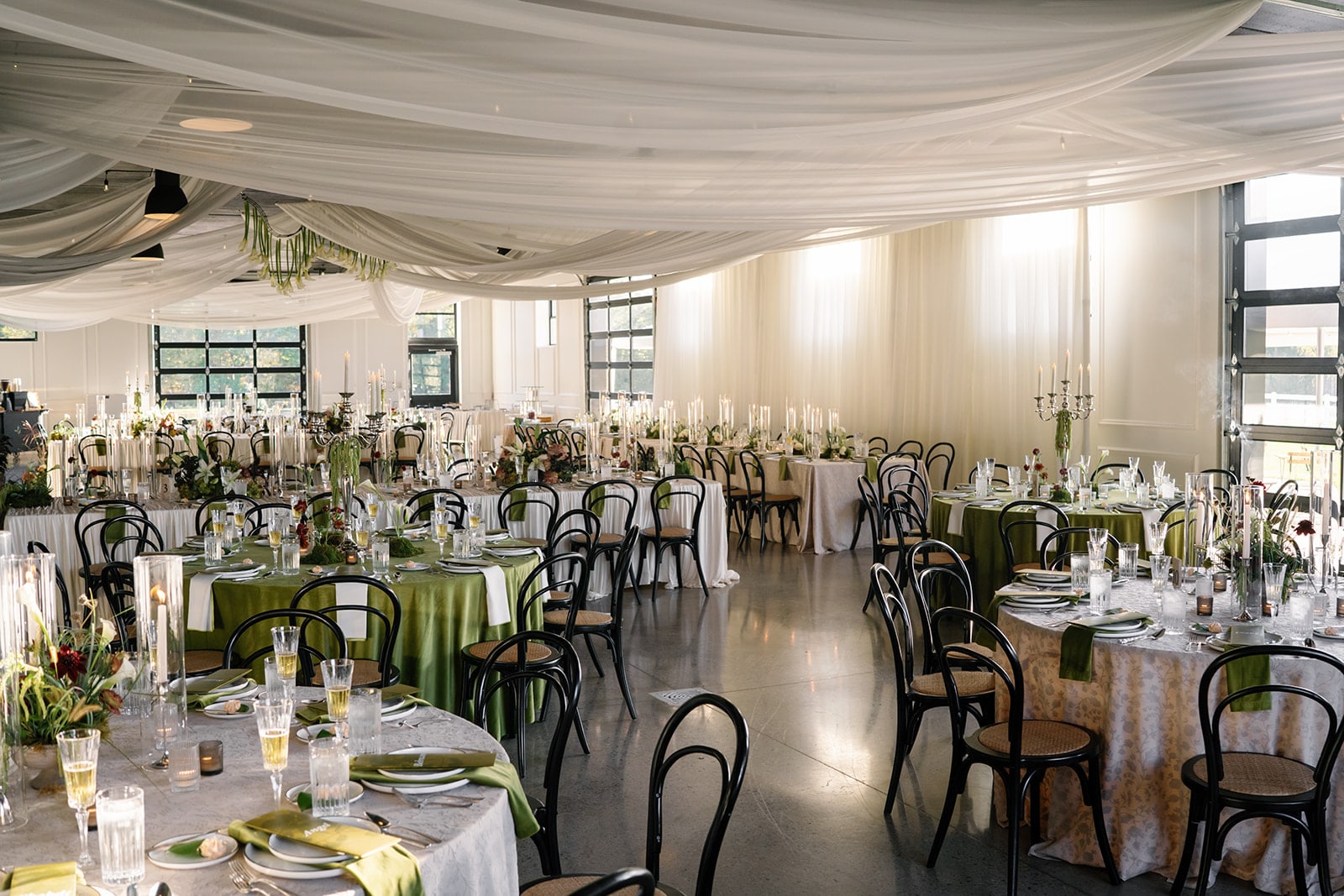 The event center draped in white, tables set with green linens and candlelight